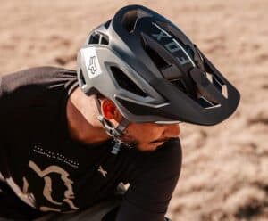 Helmet for mountain biking, black and gray MTB helmet on rider, outdoor trail gear.