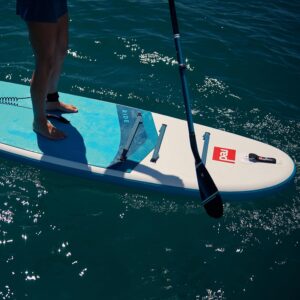Stand-up paddleboard with paddle on water, outdoor water sports equipment.