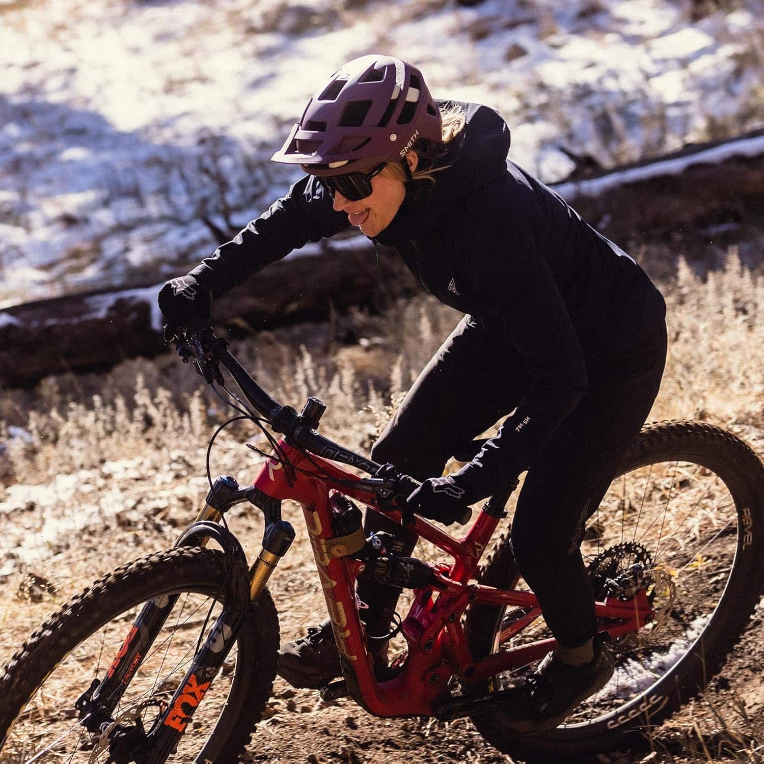 High-performance mountain biking on rugged terrain with a female rider in full gear.
