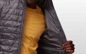 Lightweight black insulated outdoor jacket with inner lining and zipper pockets for camping, hiking, and survival gear. Durable and weather-resistant for outdoor adventures.