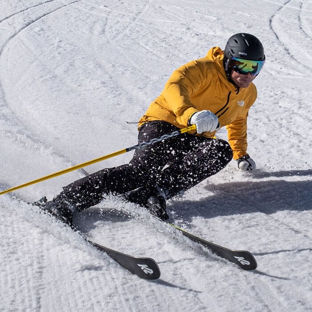 Blizzard skiing athlete in yellow jacket on snowy mountain, extreme winter sports, professional skier gear, outdoor adventure, alpine skiing, survival gear for winter sports, extreme cold weather equipment, mountain sports equipment, survival gear and beyond, rugged winter outdoor gear.