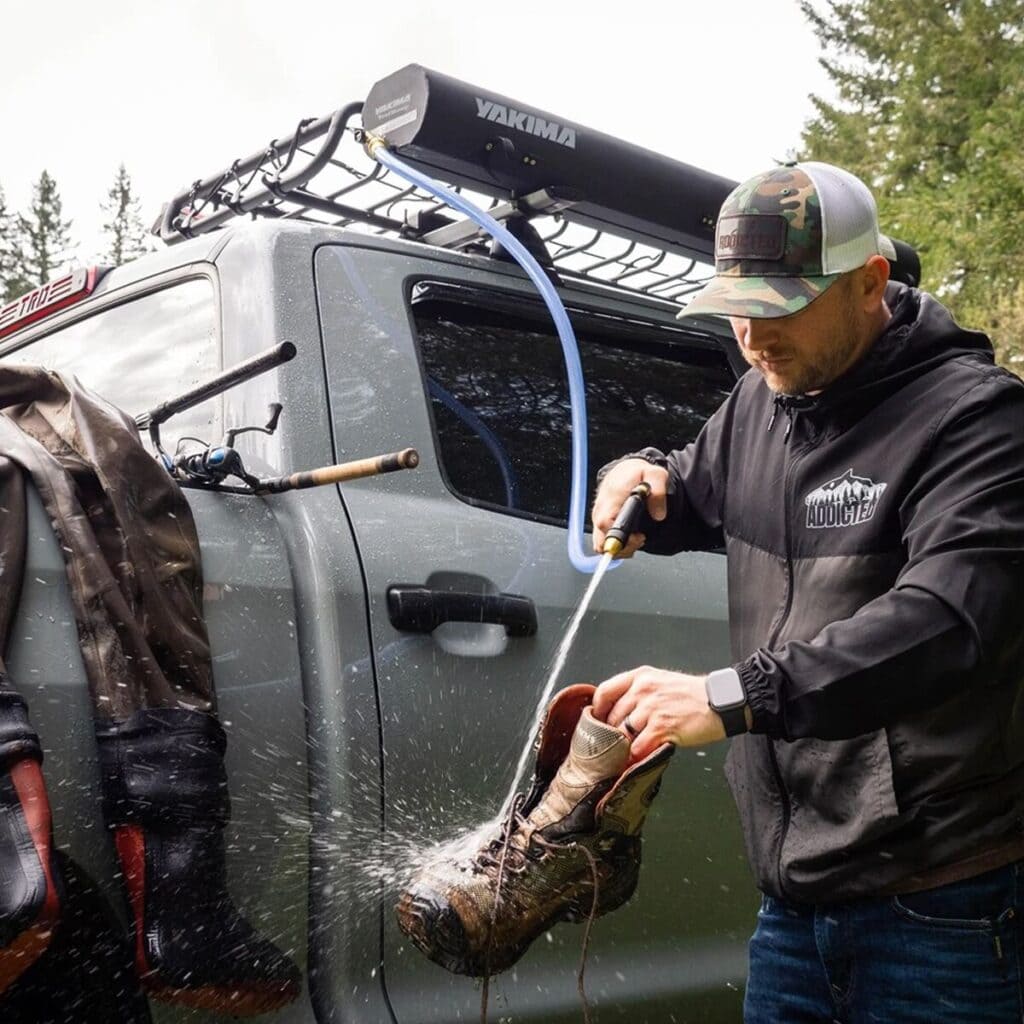 Waterproof tactical boots being rinsed off after outdoor adventure or survival activities. Ideal for rugged terrain, camping, hiking, and emergency preparedness. Durable footwear for survival gear enthusiasts.